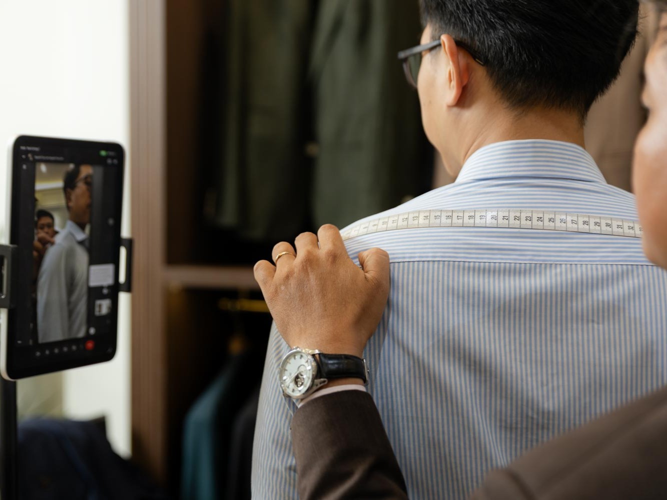 A V.Man Tailor specialist provides real-time measurement guidance through a personalized video consultation, helping clients achieve accurate body measurements from anywhere in the world.