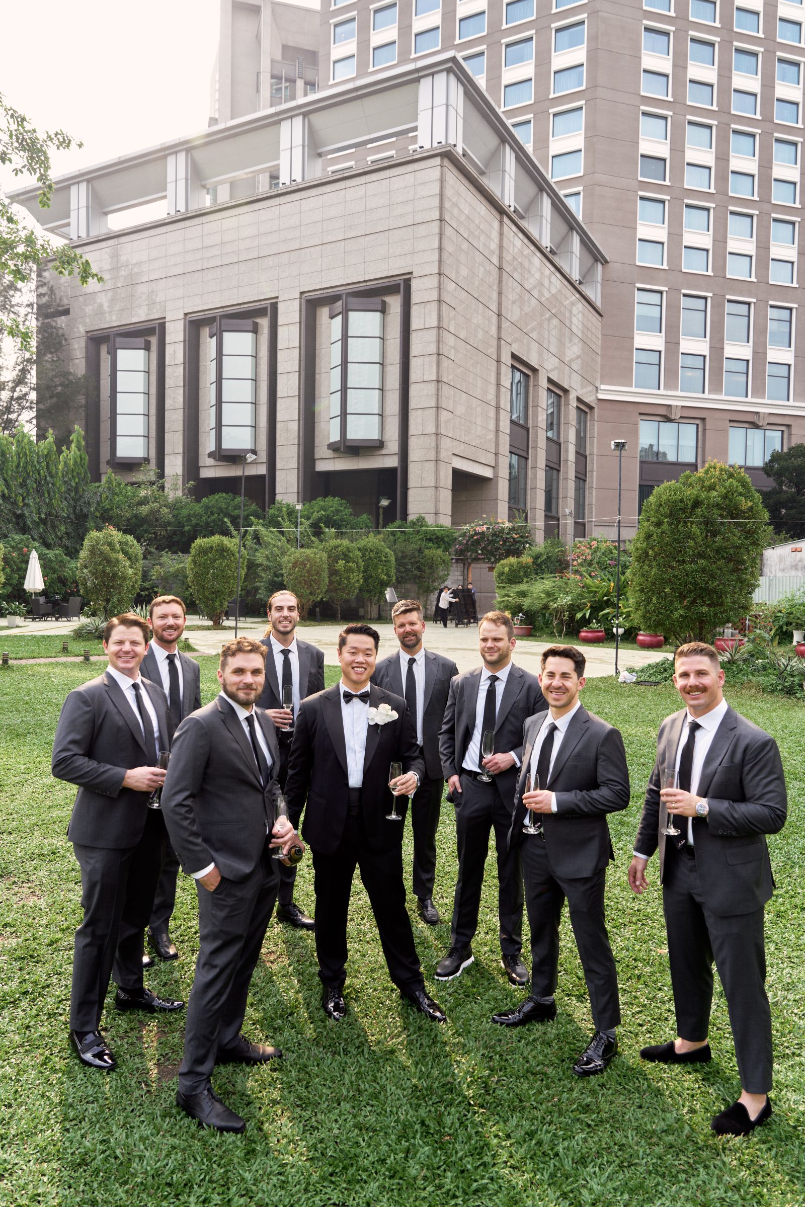 Groom and Groomsmen in Bespoke Suits by V.Man Tailor: Lightweight fabrics and Half Canvas construction create a comfortable, breathable fit while maintaining a polished and sophisticated look for warm-weather weddings.